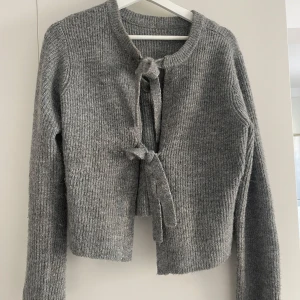 Grå ribbad kofta med knytband - Säljer en kofta från VILA, märke object. Väldigt fin att ha både knuten eller uppknuten. Går även att ha den bakofram och ha knytningen i ryggen istället. Storlek M🌷 skriv gärna för bilder med den på!