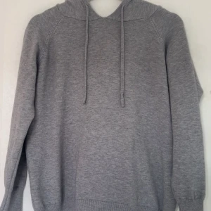 Grå hoodie - Säljer en stilren grå hoodie med långa ärmar och justerbar huva. Perfekt för en avslappnad look. Mjuk och bekväm att bära. Skirv erst bästa pris 