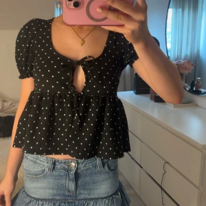 Svart prickig blus med knytning - Snygg svart blus med vita prickar och en söt knytning framtill✨✨💓aldrig använd 