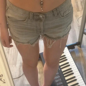lågmidjade jeansshorts - Säljer ett par grå jeansshorts med slitna detaljer. Aldrig använda, ifrån zara!