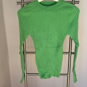 Ny, oanvänd, ärtgrön tröja från Pieces - Ny, oanvänd, ärtgrön tajt men stretchig tröja från Pieces i storlek M. Prislappen kvar. Nypris 330kr.