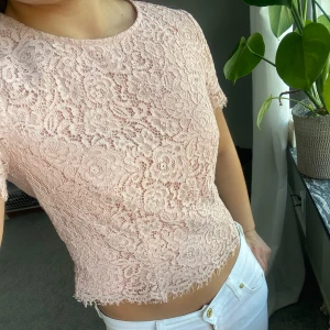 Rosa spetsblus - Säljer en superfin och söt rosa spetsblus. Blusen har ett blommigt mönster och en fin kantdetalj längst ner. Passar perfekt nu på våren eller i sommar! 🌸