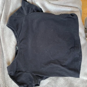 Svart t-shirt - Svart magtröja från SHEIN. Bra skick.