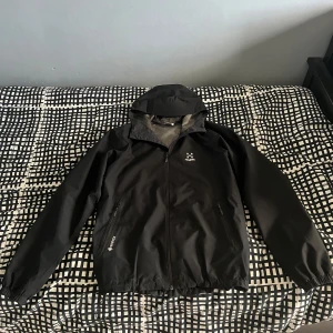 Haglöfs jacka - Säljer en svart Gore-Tex jacka från Haglöfs, Jackan har dragkedja framtill och justerbar huva. Den är långärmad och har praktiska fickor med dragkedjor. Jackan är använd ett fåtal gånger.