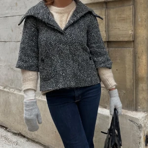 ullkappa  - Jackan har trekvartsärmar och knappar framtill. Nopprig som syns knappt pga att det är ull. 