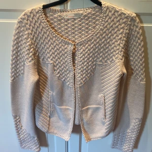 Beige stickad kofta från Odd Molly - Säljer en snygg beige stickad kofta från Odd Molly med ett unikt mönster. Koftan har långa ärmar och en rund halsringning. Perfekt för att hålla sig varm och stilren under kyligare dagar.