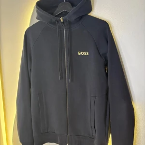 Svart huvtröja från Boss - Boss hoodie i bra skick storlek S men skulle säga att den passar M då passformen ska sitta lite löst.