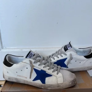 Golden goose skor  - Snygga vita sneakers från Golden goose. Dom är i bra skick förutom att det är ett litet hål i sulan , men en skomakare kan enkelt fixa de , hålet är dessutom inget man tänker på därav priset.