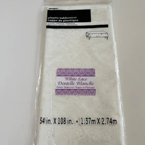 Plastduk - Bilderna visar en vit plastduk med spetsmönster från märket Unique. Produkten är återanvändbar, tvättbar och vattentät. Storleken är 137 x 274 cm (54 x 108 tum). Förpackningen är oöppnad och duken passar perfekt till fester, middagar eller dekoration.