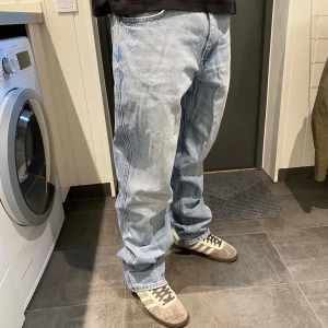 Zara ljusblå baggy jeans - Säljer ett par Zara jeans i ljusblå denim. De har en baggy passform med raka ben och fem fickor. Jeansen är tillverkade i bomull och har en avslappnad, loose vibe som passar perfekt till sneakers och hoodie. Säljer pga att de är för långa för mig (är 179cm)