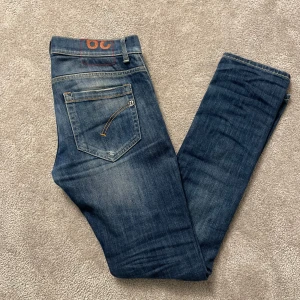 Dondup George  - Snygga Dondup jeans i mörkblå tvätt med klassiska fem fickor. Slim fit-modell med raka ben och låg midja. Perfekta för dig som gillar stilrena och bekväma jeans med coola detaljer.