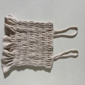 Beige topp med volang - Supersöt beige linnetopp från h&m med smockad struktur och volangkant nertill. Perfekt att ha som festtopp