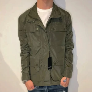 Lawrence gray jacka (Helt ny) - Snygg olivgrön jacka från Lawrence gray med dragkedja och tryckknappar framtill. Materialet är lätt och känns skönt att bära under vår och höst. Nypris 2200kr - mitt pris 649kr! Skick 10/10 helt ny med tags kvar. Hör gärna av er om ni har några funderingar.