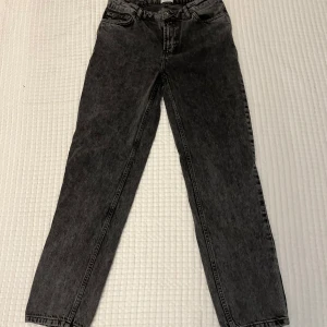 Svarta jeans från Grunt - Snygga svarta jeans från Grunt i tvättad look. Jeansen har hög midja, raka ben och klassisk femficksdesign. Tillverkade i ekologisk bomull för en skön och hållbar känsla. Perfekta till sneakers eller boots.