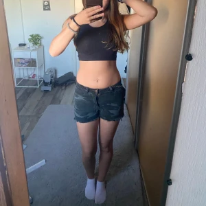 Camouflage jeansshorts - Säljer ett par snygga jeansshorts med militärmönster i mörkgrön och svart ton. 