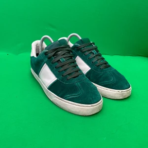Valentino Flycrew  - Snygga Valentino Flycrews sneakers i grön mocka med vita skinnpaneler och svarta snören. Platt sula med coola nitar baktill och mönstrad yttersula. Perfekt för dig som vill sticka ut med exklusiva detaljer och sportig vibe. Tappat 3 nitar! Dustbag ingår, Nypris 8000kr varan tillverkas inte och farfar är priset och skon speciell/ovan! Hör av vid minsta fundering