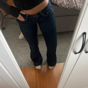 Bootcut jeans  - Säljer ett par mörkblå bootcut jeans från din vintege shop med kontrastsömmar och låg midja. Jeansen har klassisk femficksdesign, dragkedja och två knappar då jag ville få in dom i midjan. Materialet är jeans med lite stretch för skön passform. Perfekta för dig som gillar retrovibe och snygg siluett. Uppsydd för mig som är 157cm, stolek xxs men skulle säga de är xs 