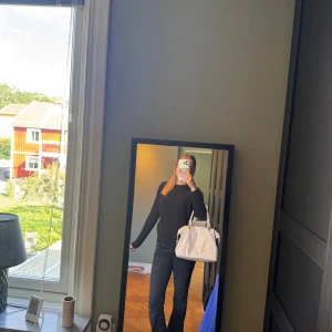 Svart ribbad stickad tröja - Säljer en svart stickad tröja med ribbad struktur och rund hals. Tröjan har lång ärm och en klassisk, enkel design som är lätt att matcha med jeans eller kjol. Perfekt för dig som gillar stilrena och bekväma plagg med lite edge.