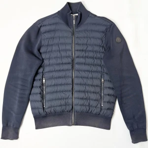 Moncler Cardigan - Stilren cardigan från Moncler. L sitter S/M. Skick: 7/10, slitna muddar & bytt dragkedja. Retail: 12,000 SEK. 