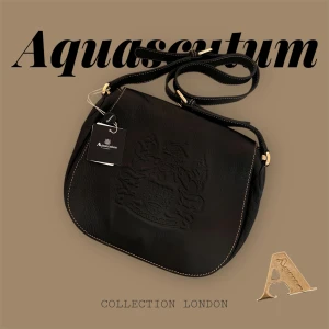 Helt ny Aquascutum London läderväska - Säljer en helt ny Aquascutum väska i läder. Väska är med prislappen kvar, alltså helt ny med inga defekter. Vintage och perfekt som både ett present till någon men även till dig som vill ha en exklusiv touch till din outfit.  Väskan är i svart läder med rutig mönster och guldiga detaljer. Den har även en praktiskt fack med dragkedja för säker förvaring. Med justerbar axelrem med gulddetaljer.    Värdet på väskan ligger på ca  2 000kr-2 500kr   PRISET ÄR FÖRHANDLINGSBART!