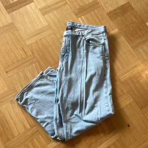 Ljusblå jeans, Sweet SKTBS  - Ljusblå jeans från Sweet SKTBS i storlek XL. Klassisk femficksmodell med broderad logga vid fickan och snygga kontrastsömmar. Jeansen har loose/relaxed passform och är tillverkade i bomullsdenim. Perfekta för en avslappnad streetstil.  Köpta från Junkyard för ca 1 år sedan. sparsamt använda sedan dess. Mått: Längd (midja-fot) 117cm, Midja bredd: 53cm, Längd ben: ca 80cm. Ben bredd ca 30cm