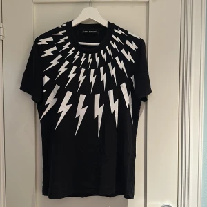 Neil Barrett svart t-shirt  - Säljer en Neil Barett tisha i storlek M samt färg svart och vit. Skick 8/10 små tecken finns på användning så som t.ex trådar osv. Kom dm för fler frågor/bilder osv, pris ej hugget i sten.
