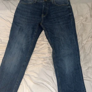 Jack & Jones Comfort Mike jeans blå. 31/32 - Säljer ett par Jack & Jones Comfort Mike jeans i klassisk blå. Modellen har raka ben, fem fickor och snygga kontrastsömmar. Jeansen är tillverkade i slitstarkt denim och har normal passform med midwaist. Perfekt för dig som gillar en enkel och tidlös stil. Använt dem max 4 gånger!