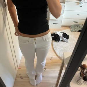 Vita lågmidjade jeans - Säljer ett par vita jeans från ONLY med bootcut-modell. Byxorna har låg midja. Storlek XS, längd 30💕använd en gång