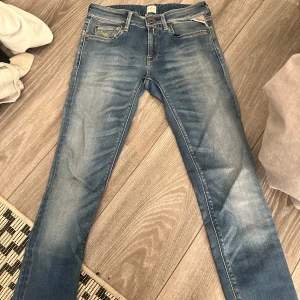 Blå Replay jeans med broderade fickor - Snygga blå jeans från Replay med klassisk tvätt och coola broderade bakfickor. Jeansen har normal passform, raka ben skinny och detaljer i gult. Perfekta för dig som gillar en avslappnad men stilren look.