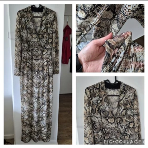 Långklänning med ormmönster - Snygg långklänning med coolt ormmönster i beige, bruna och svarta toner. Klänningen har omlott-skärning, lång ärm och v-ringad hals. Mjuk och stretchig känsla, perfekt för dig som vill sticka ut.