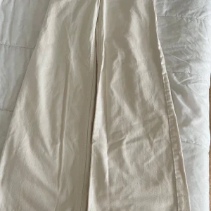 Beiga wide byxor från H&M, stl 34 - Snygga beiga byxor från H&M i storlek 34. De har en rak och vid passform med hög midja och är tillverkade i ett mjukt bomullstyg. Perfekta för en chill och stilren look.