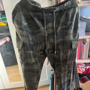 Cargopants Camo  - Ett par cargopants från Amisu. Med grön camouflage-mönster.  Storlek 36 🌻
