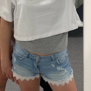 Ljusblå jeansshorts med spetskant💞 - Snygga ljusblå jeansshorts med slitna detaljer och vit spetskant längst ner.
