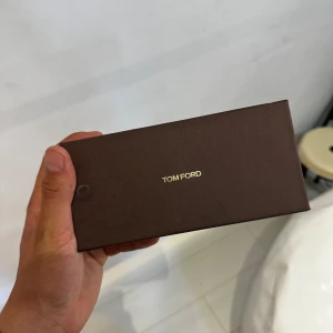 Svarta solglasögon från Tom Ford - Snygga svarta solglasögon från Tom Ford med klassisk pilotform. Bågarna har svarta detaljer framtill och tunna metallskalmar i silver med svarta ändar. Kommer med originalfodral. Perfekta för dig som vill ha en stilren och lyxig look.