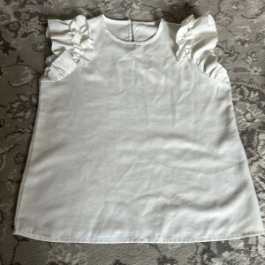 Vit blus med volangärmar - Vit blus med volangarmar. Materialet är luftigt och ett perfekt klädesplagg till sommaren