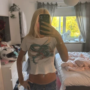 Vit croppad t-shirt - Säljer en super söt vit croppad t-shirt med tryck som tyvärr aldrig kommer till användning 💘