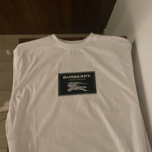 Vit Burberry t-shirt  - Vit t-shirt från Burberry. Tröjan är helt ny då jag fick den hade jag redan köpt en likadan tröja. Den är i helt ny skick aldrig använd man får med alla lappar. Skriv vid funderingar. Den står vara i xxl men jag har L och den sitter perfekt på mig.