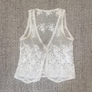 Spetsväst - Somrig väst eller topp i offwhite spets från vero moda. Perfekt att ha över bikinitopp eller en sommarklänning! 50% bomull 50% nylon ☀️obs! lite mörkare under armhålorna, ses sista bilden 🫶🏻