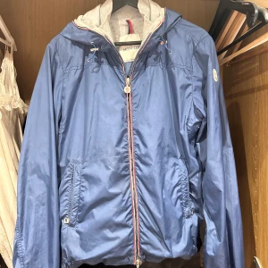 Moncler jacka windbreaker  - En riktigt snygg Moncler urville windbreaker, använd men fortfarande i ganska bra skick. Har några få synliga tecken på användning men knappast märkbara vid användning, därav priset. De två sista bilderna visar lite defekter jackan fått med tiden. Storlek S, foto som visar äktheten finns. Hör av er vid frågor!