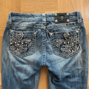 Low Rise Miss Me jeans! - Jätte snygga låg midjade bootcut vintage Miss Me jeans i storlek 28/passar även på mindre storlekar. Det finns inga synliga defekter och är i perfekt skick för ett par vintage jeans! Jeansen har även en fin brodering med strassel på bakfickorna och brodering på framsidan! Pris går alltid att diskuteras vid snabb affär. Fler frågor är det bara att DM’a!!💕💕