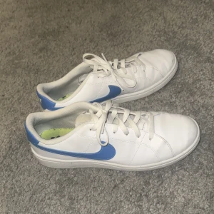 Vita Nike sneakers med blå swoosh - Fräscha nästintill oanvända Nike skor, ord pris runt 1100-1300. Inte använda mycket alls, vilket inte är så svårt att se på bilderna, endast använda ett par gånger på gymmet men märkte snabbt att dom inte riktigt passade mig, storlek 43.