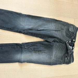 Grå jeansbyxor från Please - Snygga grå jeansbyxor från Please med fem knappar i gylfen och klassiska bakfickor, varav en har en liten hjärtformad detalj. Byxorna har en något tvättad look och normal passform. Bra skick. Stora i storleken 