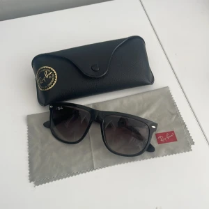Svarta solglasögon från Ray-Ban boyfriend  - Klassiska svarta solglasögon från Ray-Ban med Wayfarer-inspirerad form. Glasögonen har mörka tonade linser och kommer med originalfodral och putsduk. Perfekt accessoar för att lyfta din stil. De är dom mindre boyfriend storleken skriv vid minsta fråga elelr fundering säljer då jag inte har någon användning av dem!