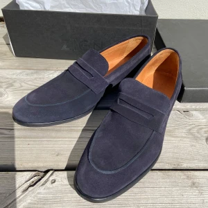 Mörkblå mocka loafers - Säljer ett par stilrena mörkblå loafers från Zign i mjuk mocka. Skorna har klassisk design med rund tå och platt sula, samt diskreta sömmar och innersula i läder. Riktigt fina! 