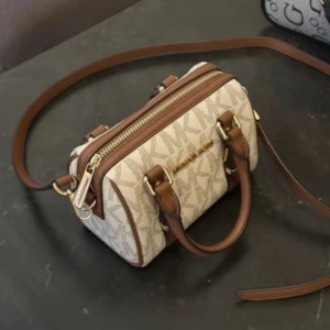 Beige och brun axelväska från Michael Kors - Söker en  beige  eller svart axelväska  från Michael Kors med bruna detaljer och guldiga metalldelar