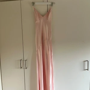 Rosa balklänning  - En jättefin ljusrosa balklänning i satin med slits vid sidan av benet och öpppen rygg med knytning. Klänningen är i storlek 36/S. Använd en gång, förra året på balen så i nyskick. Kom privat för fler bilder eller liknande.