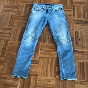 Replay Grover jeans i ljusblå denim - Säljer ett par Replay Grover jeans i ljusblå tvätt med klassisk femficksdesign. Jeansen har raka ben, diskreta slitningar och en snygg vintage-look. Märkespatch bak i midjan och tydliga Replay-detaljer. Perfekta för dig som gillar en avslappnad stil. Dom är i storlek W31L32
