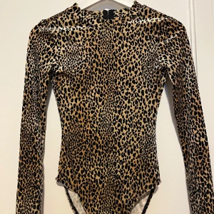 Leopardbody - Långärmad body med leopardmönster, med öppen rygg och sammetsmaterial. Använd fåtal gånger. Pris kan diskuteras🤎