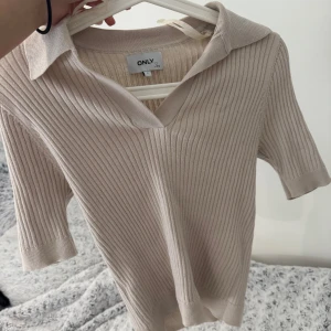 Beige ribbad  från ONLY - Säljer en beige ribbad från ONLY med krage och v-ringning. Endast använt 1-2 gånger!