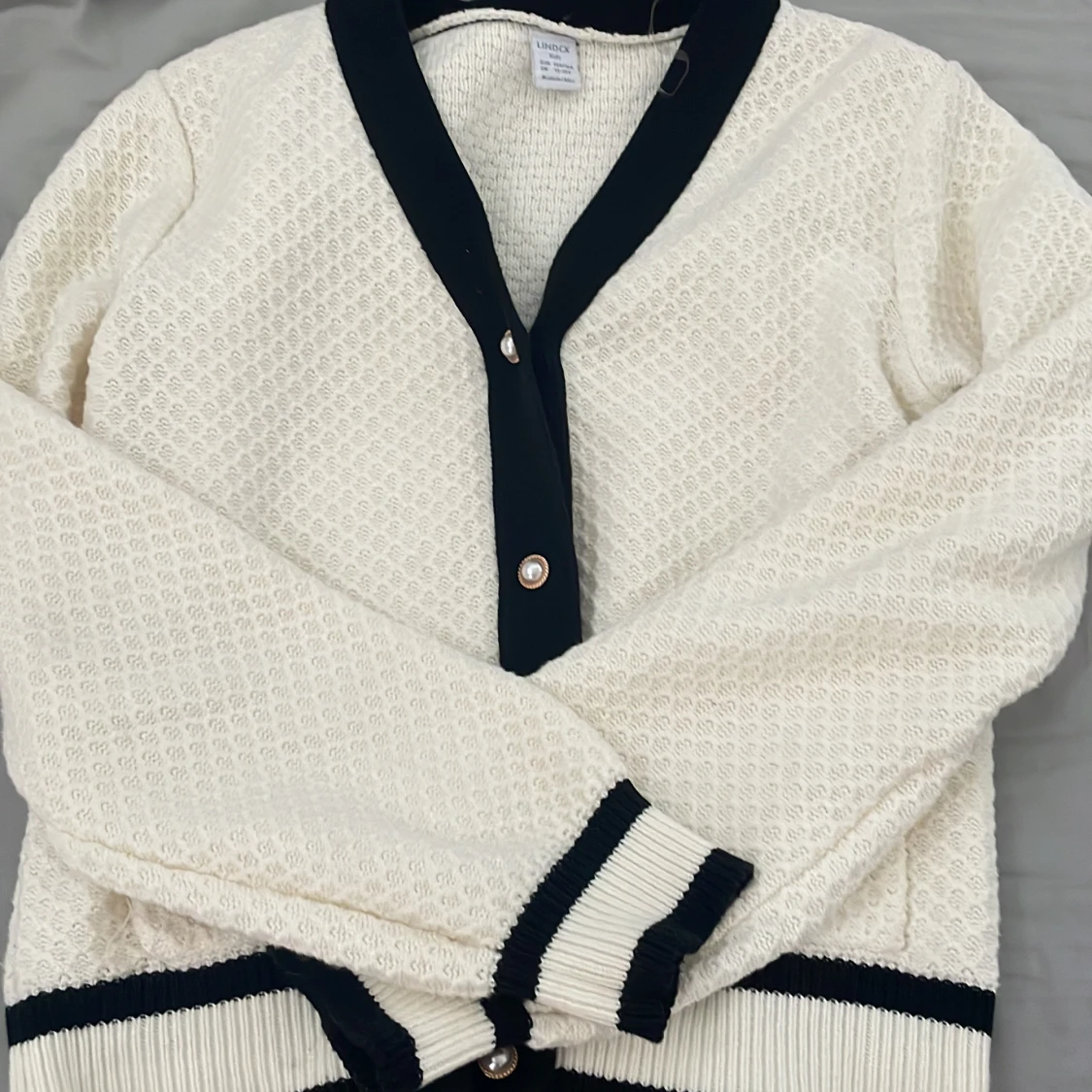 Vit kofta med svarta detaljer